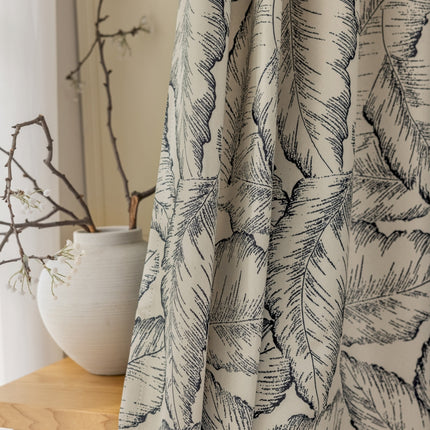 a close up of a curtain with a plant in the background