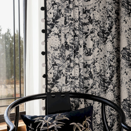 a black and white wallpapered room with a chair next to a window