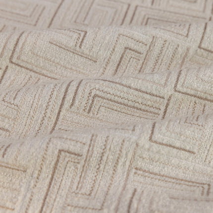 a close up view of a bed with a beige bedspread