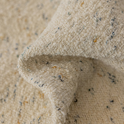 a close up of a white blanket with blue and yellow speckles