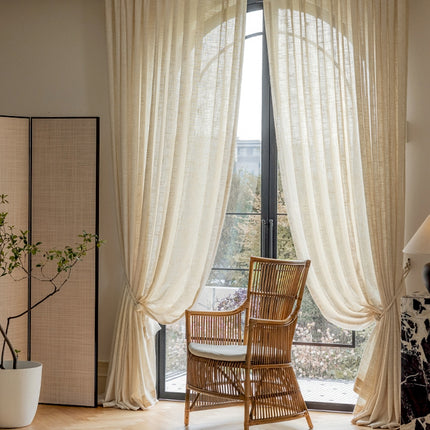 a chair sitting in front of a window next to a potted plant