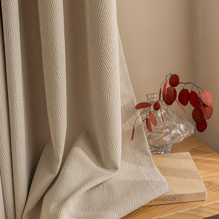 a vase of flowers sitting on a table next to a curtain