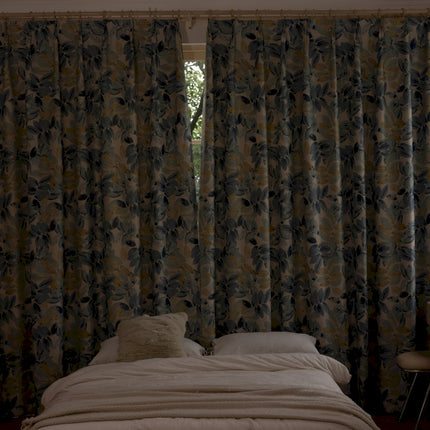 a bed sitting under a window next to a window covered in curtains