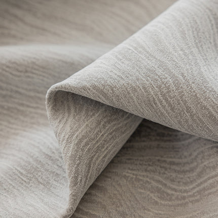 a close up of a bed with a gray blanket