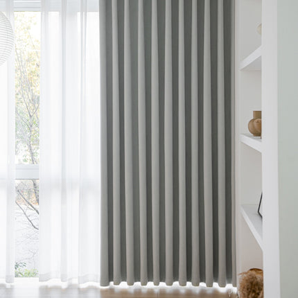 a window with a gray striped curtain in front of it