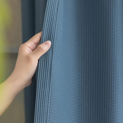 a person is holding the curtain with their hand