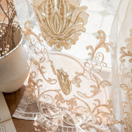 a close up of a sheer curtain near a potted plant
