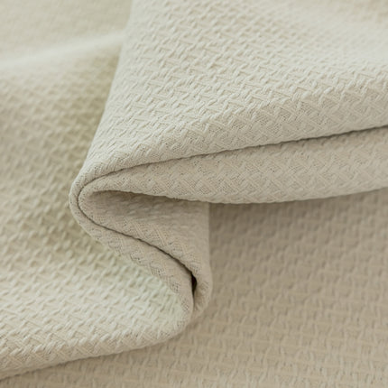 a close up of a white blanket on a bed