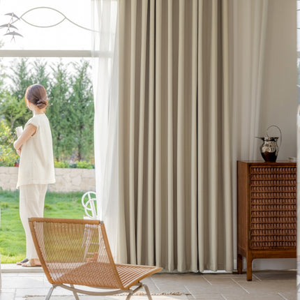 a woman standing in a living room next to a window