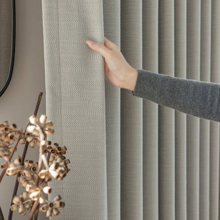 a person is holding a curtain in front of a window