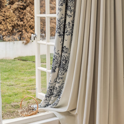 a window with a curtain and a basket on the window sill
