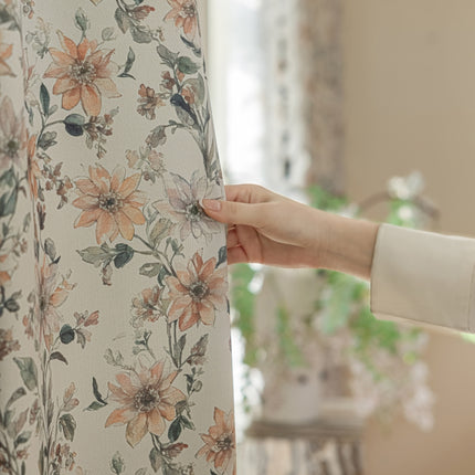 a person holding a curtain with a flower pattern on it