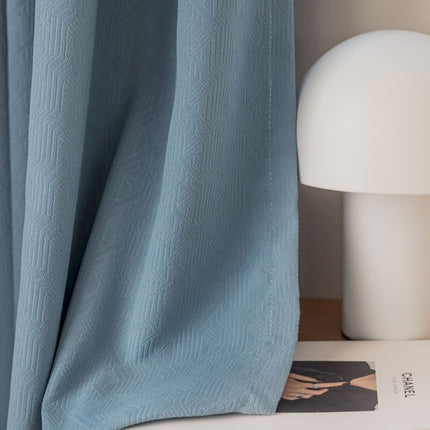 a white lamp sitting next to a blue curtain