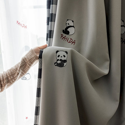 a person holding onto a curtain with panda embroidered on it