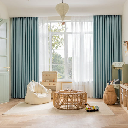 a child's room with a large window and a wicker chair