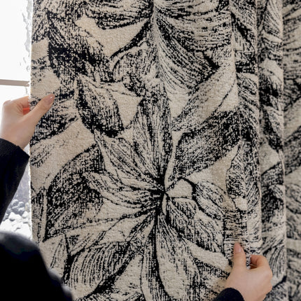 a person holding a piece of fabric in front of a window