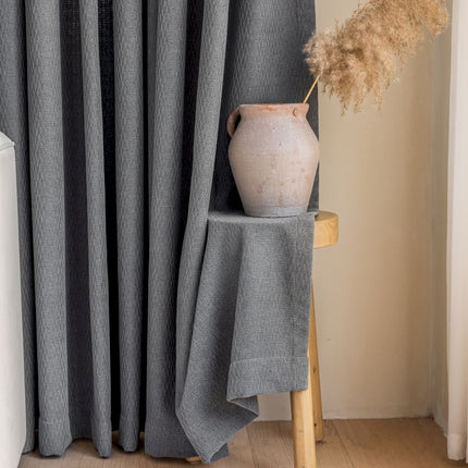 a vase sitting on top of a table next to a curtain