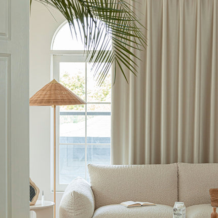 a living room with a white couch and a palm tree