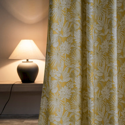 a lamp sitting next to a yellow curtain