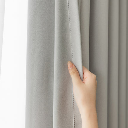 a person's hand on the curtain of a window