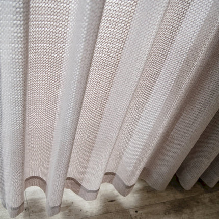 a close up of a white curtain on a wooden floor