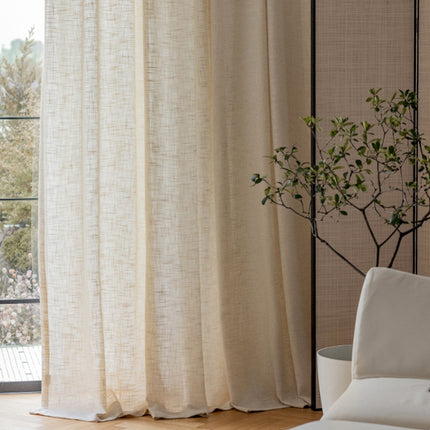 a white couch sitting next to a window covered in curtains