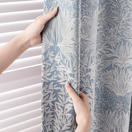 a person is pulling up a curtain with their hand