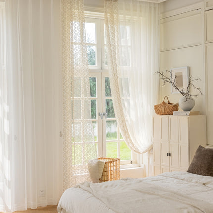 a bedroom with a white bed and white curtains