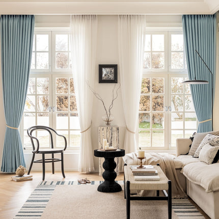 a living room filled with furniture and large windows
