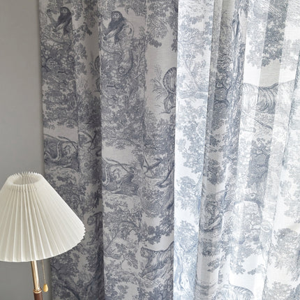 a lamp sitting next to a curtain with a bird on it