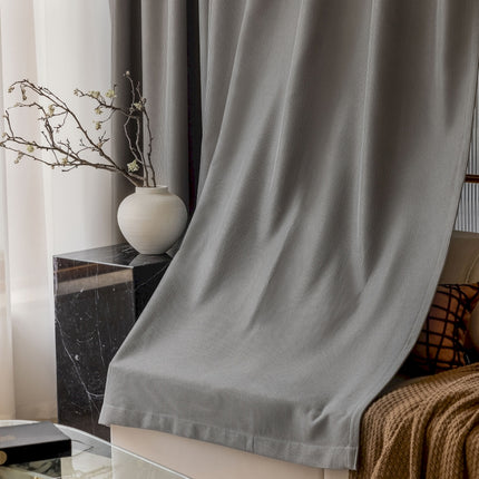 a white vase sitting on top of a table next to a window