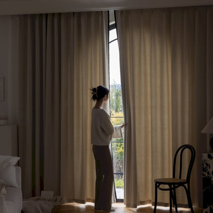 a woman standing in front of a window