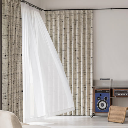 a room with a chair, speakers and a curtain