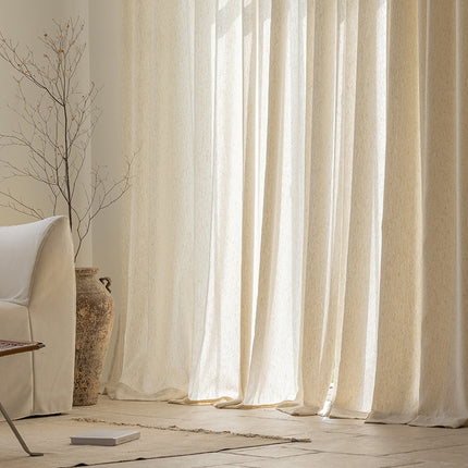 a living room with a white couch and white curtains