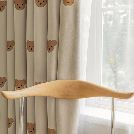 a window with a curtain with a bear pattern on it
