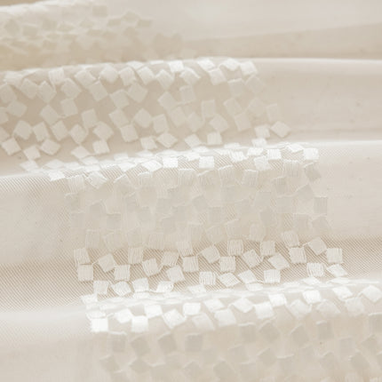 a close up of a white cloth with squares on it