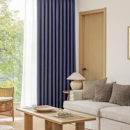 a living room filled with furniture and a window covered in blue curtains