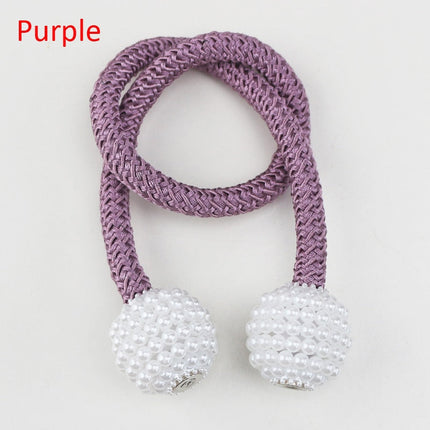 attache violet et blanc orné de perles, utilisé pour les rideaux décoratifs avec un système d'attache magnétique.